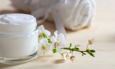 Fototapeta na wymiar Moisturizing cream and almond blooms on wooden background