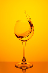 Splash of water in a glass on yellow