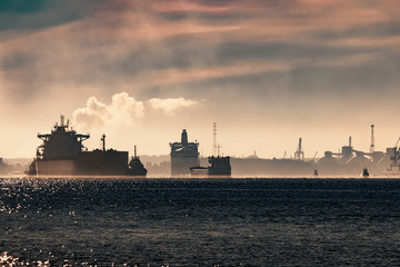 Cargo ship silhouette entering a port of Riga at the morning