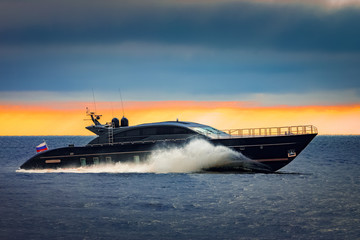 Fototapeta premium Black elite speed motor boat moving fast from Baltic sea