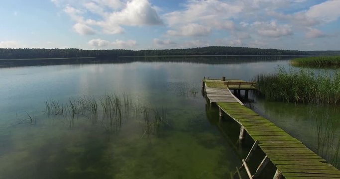 Lake landscape with cloud reflections, wooden bridge