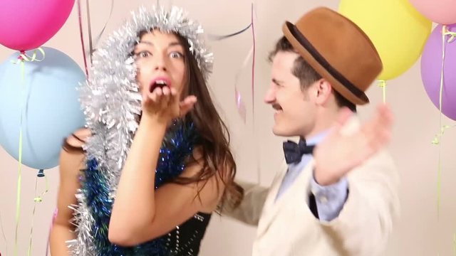 Cute young couple having fun dancing in party photo booth