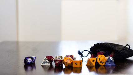 Colorful roleplaying dice scattered on a table with reflection