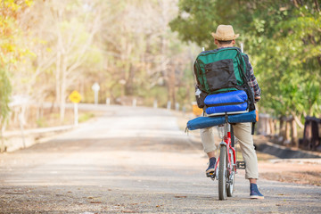 Asian Man Riding Bicycle on Rural Road  Go Adventure Trip with backpack