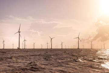 Wind turbines at sunset. Ecology wind against cloudy sky background with copy space