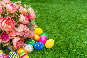 Fototapeta na wymiar Easter eggs with artificial flower on Fresh Green Grass