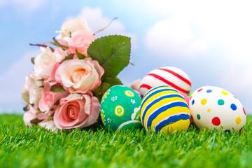 Easter eggs with artificial flower on Fresh Green Grass
