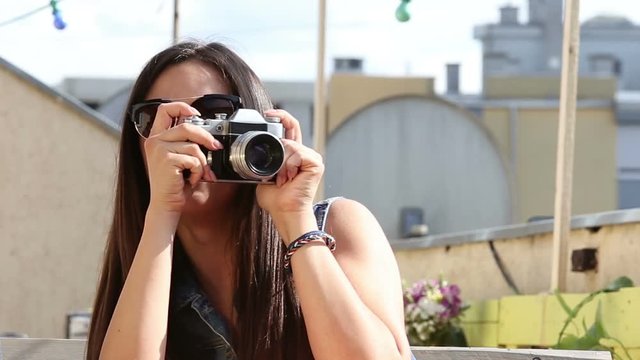 Close up of beautiful brunette woman taking photos with old fashioned camera