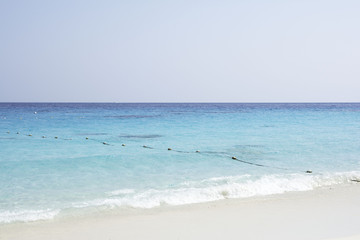 Beautiful white sand beach on the Southeast Asia island with blue sea, little wave and buoyancy.