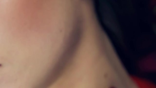 Video footage shot close-up of a girl's lips with red lipstick. The girl opens her lips and smiles. Slow motion. Professional lighting on face of girl in studio. Turns her head aside