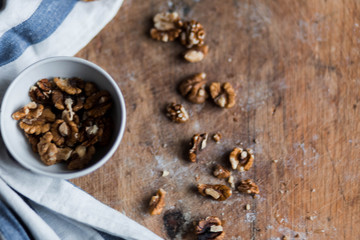 walnuts and honey white in a small bowl blue white striped kitchen towel on wooden background chalkboard closeup, foodfoto