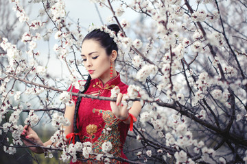 Naklejka premium Geisha in red kimono in sakura