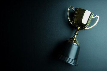 Golden trophy isolated on black background with copy space.Concept winner.