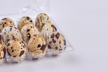 Quail eggs in plastic tray. Eggs on white background. What to eat on diet.