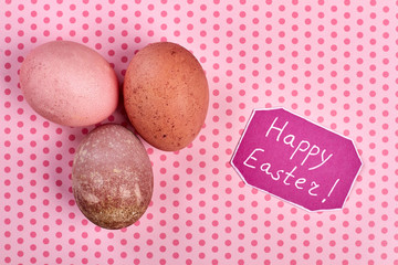 Eggs on pink background. Happy Easter card. Easter comgratualtory composition.