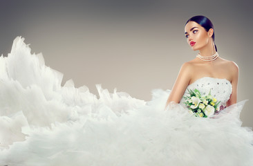 Beauty model bride in wedding dress with long train. Beautiful fiancee in elegant white wedding dress