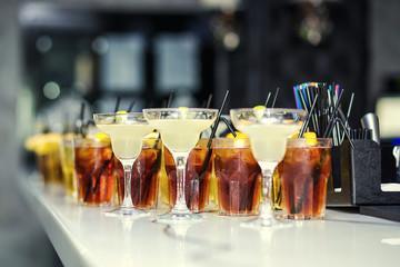 Glasses with cocktails, champagne, juice.Glasses on the white table, A row of champagne glasses,cocktails.Furshet, catering.Glasses for champagne or wine.