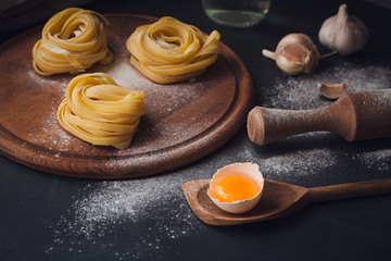 Raw homemade pasta with flour and spices on the rustic background.