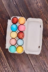 Fototapeta na wymiar Easter egg tray, brown wood. Top view of painted eggs. Simple Easter food ideas.