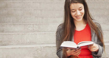 young beautiful woman reading book in old center of europe city (Knowledge, development, education,...