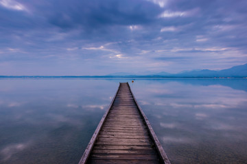 Fototapeta premium Morgendämmerung über einem Steg am Chiemsee, Oberbayern in Deutschland