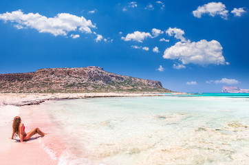Balos lagoon on Crete island, Greece. A girl on a beach with pink sand.
