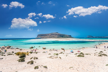 Balos lagoon on Crete island, Greece. Tourists relax and bath in crystal clear water of Balos beach.