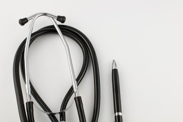 metal silver-black pen and stethoscope on a white background