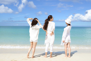 海辺で遊ぶ三人の女性