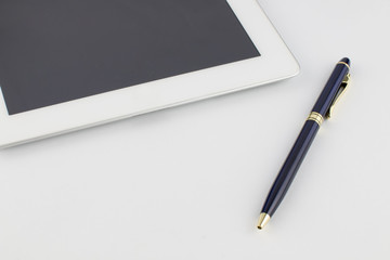 Tablet computer and a modern metal gold-blue pen on a white background