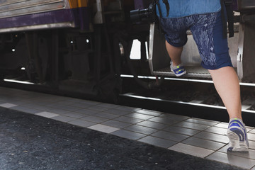 Fototapeta na wymiar Traveler girl with backpack walk up the train alone. travel journey by train