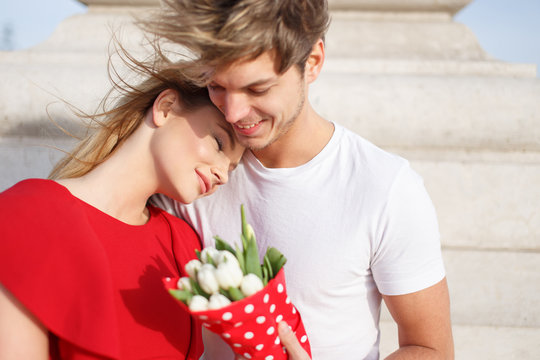 Young woman in red dress cuddle to man while dating, dream about love