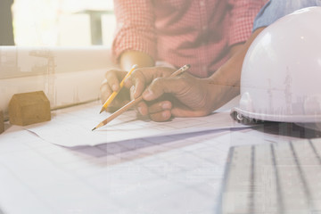 Architect or engineer meeting, working with blueprints in office, Construction concept, double exposure with crane and building under construction