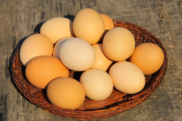 Eggs in wicker basket on wooden table