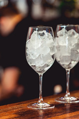 Bartender cooling out cocktail glass with ice