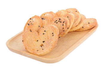 Black heart sesame biscuit in wooden plate isolated on white background