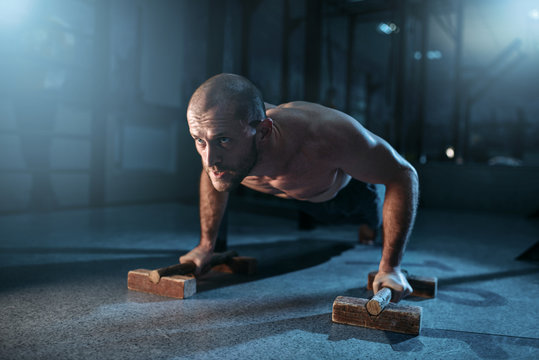 Sportsman makes pushups exercises on training