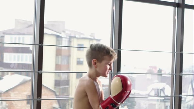 Two teenager boy Boxing each other in the gym with large windows - slow motion