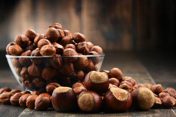 Bowl with hazelnuts on wooden table.