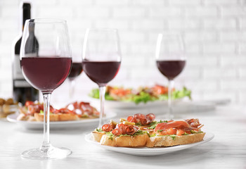 Tasty bruschetta served with wine on light background