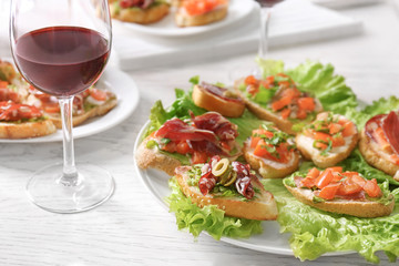 Tasty bruschetta served with wine on light background