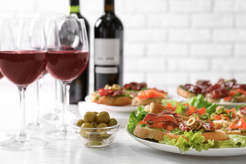 Tasty bruschetta served with wine on light background