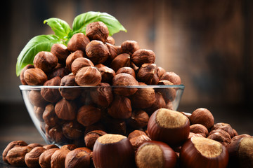Fototapeta premium Bowl with hazelnuts on wooden table.