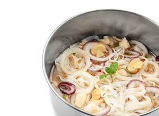 Chicken noodle soup in saucepan on white background