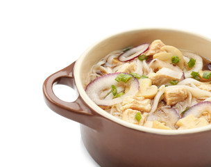 Chicken noodle soup in pot on white background