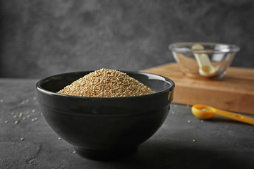 Organic quinoa seeds in bowl on dark background