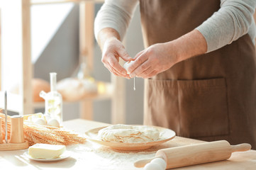 Obraz na płótnie Canvas Man making dough in kitchen