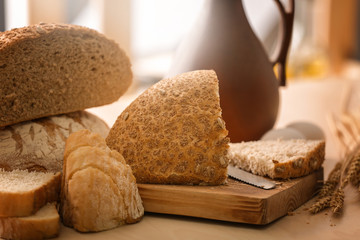 Wooden board with cut bread on kitchen table