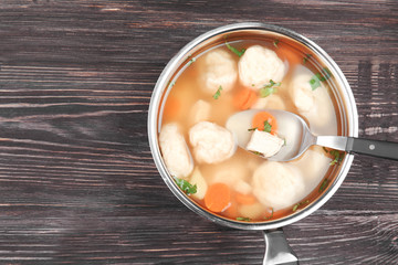 Stewpan with delicious chicken and dumplings on wooden table