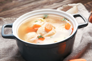 Ceramic pan with delicious chicken and dumplings on decorative napkin